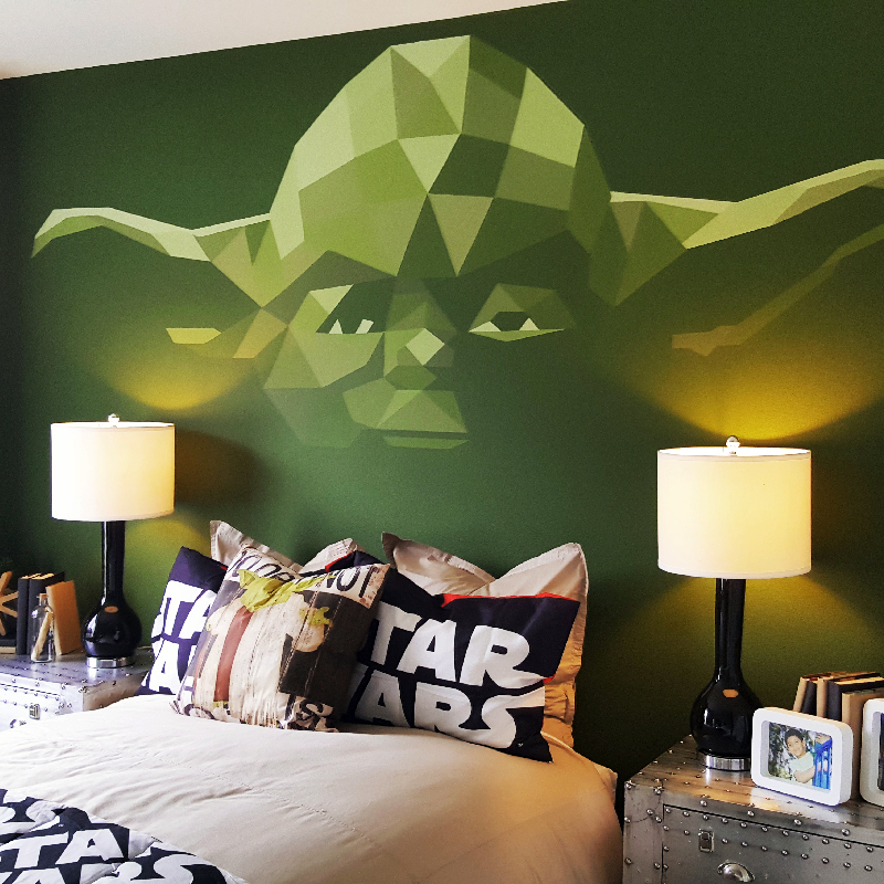A green wall with a Yoda composed of geometric shapes